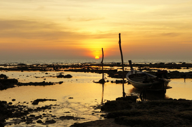 kolejne zdjęcie z wakacji w Tajladndii, przedstawia zachód słońca na plaży w zachodniej części wyspy Ko Lanta Yai parę kroków od naszego bungalowa. Odpływ odkrył skały co dało nietypowy widok zacumowanej między skałami łódki na tle zachodzącego słońca